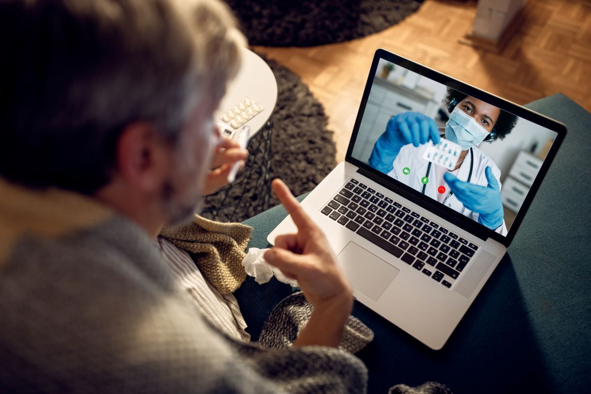 Closeup man having video call with his doctor evening home